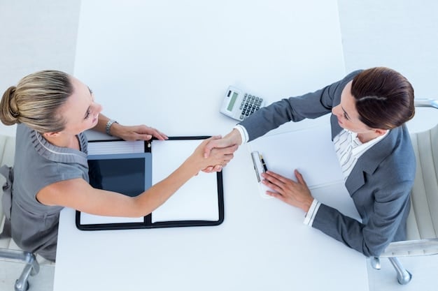 A person confidently shaking hands with a bank representative across a table, symbolizing a successful negotiation.