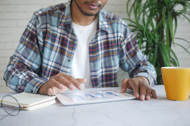 A person analyzing a graph on a tablet, with charts and data visualizations in the background representing salary and benefit benchmarks.