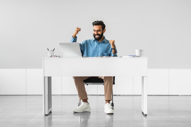 An employee is sitting at their desk, appearing relaxed and confident while using a laptop. The screen displays a user-friendly EAP portal with options for scheduling counseling sessions, accessing self-help resources, and reading articles on mental health and well-being. The image portrays the ease and accessibility of EAP services.