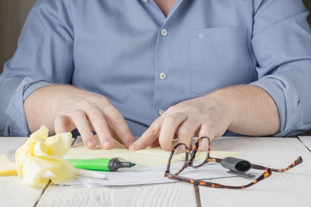 A close-up of a hand signing a disability insurance policy contract with a pen. The contract is on a desk, with a magnifying glass nearby, emphasizing the importance of reviewing the details.
