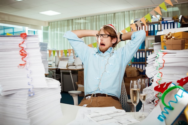 An image showing a stressed employee surrounded by piles of paperwork, with a calendar in the background showing several cancelled vacation dates, symbolizing the challenges of taking PTO.