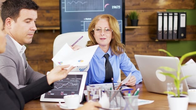 A financial planner sitting at a desk, discussing long-term care insurance options with a client. The scene is professional and reassuring, with charts and graphs visible in the background.