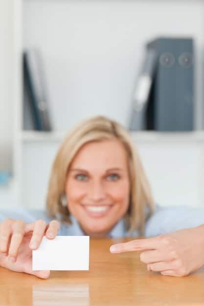 A close-up shot of a smiling employer handing a check to an employee who is holding a baby, symbolizing the financial assistance provided through adoption benefits. The setting should be a modern and welcoming office environment.