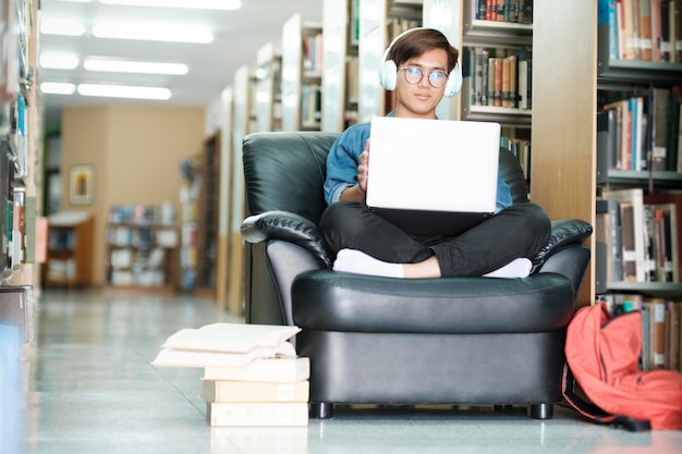 A student sitting in a library with a stack of textbooks and a laptop, focused on studying. The scene captures the essence of qualified educational expenses, such as tuition, fees, and required course materials.
