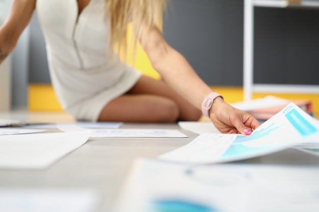A close-up view of a person meticulously reviewing financial documents and spreadsheets on a desk, highlighting the importance of detailed research in tuition negotiation. The lighting is soft and focused, emphasizing the concentration required for this task.