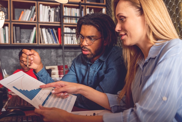 Two college students discussing financial aid options in a campus office, with a financial advisor present. The scene is collaborative and supportive, emphasizing the resources available to help students manage tuition costs.