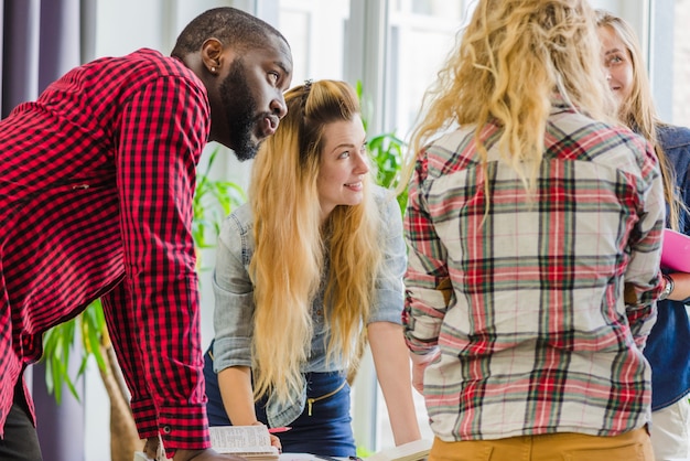 A diverse group of college students participating in a career fair. Each student is engaged in conversation with recruiters from different companies, showcasing a variety of career paths and opportunities.
