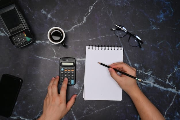 A close-up of a hand using a calculator with financial aid documents surrounding it. A pen lies on top of the documents.